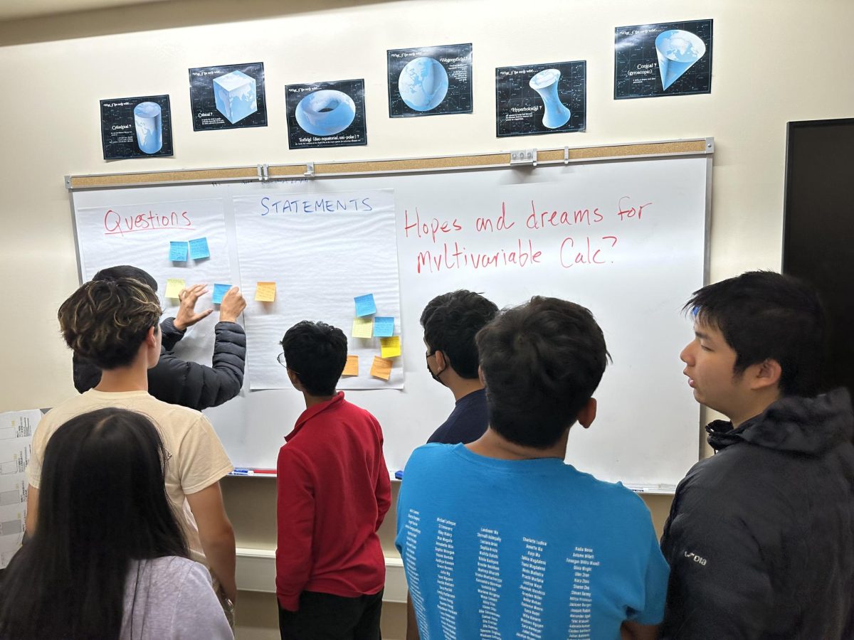 Students add sticky notes about their "hopes and dreams" for multivariable calculus to posters.